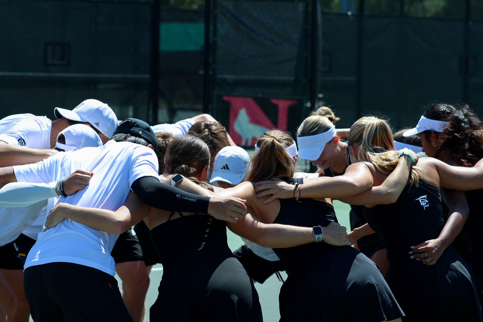 A joint huddle between the Converse men's and women's tennis teams prior to a match