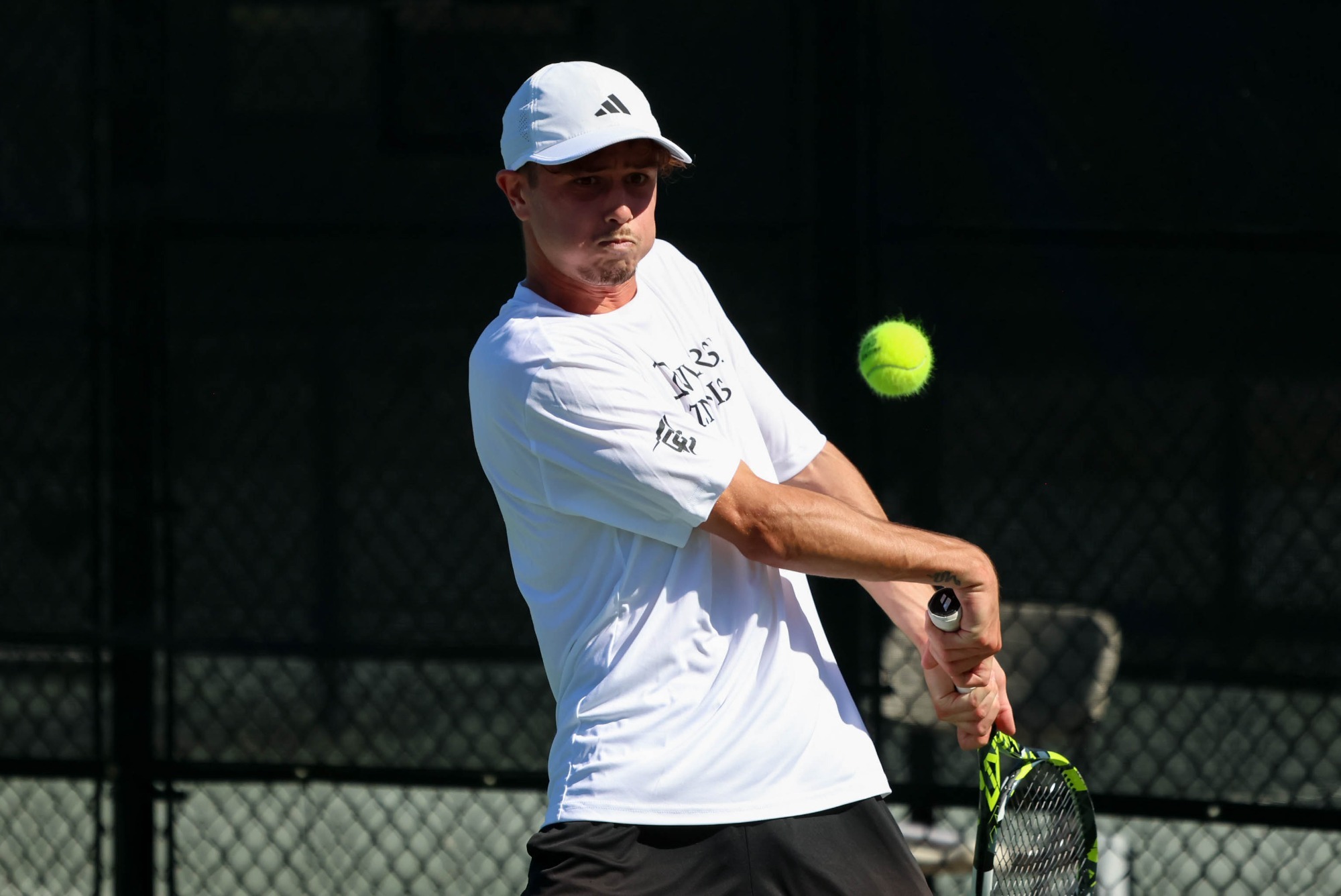 Marty eyes the tennis ball while preparing to hit it