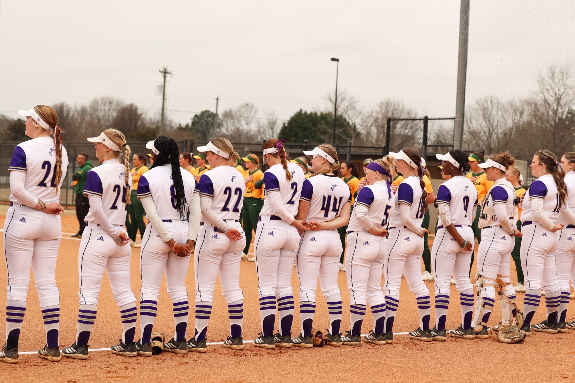 The Converse softball team stands during the national anthem