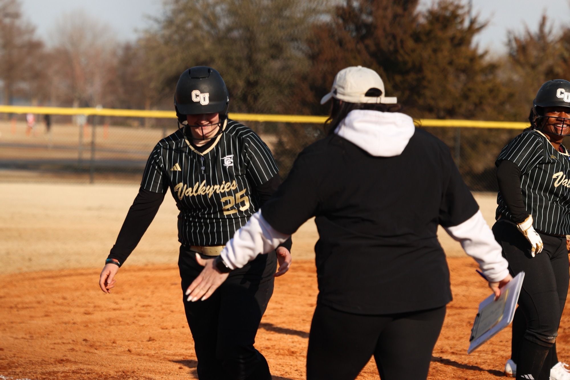 Karlie Gibson high fives head coach Jackie Huff on the field