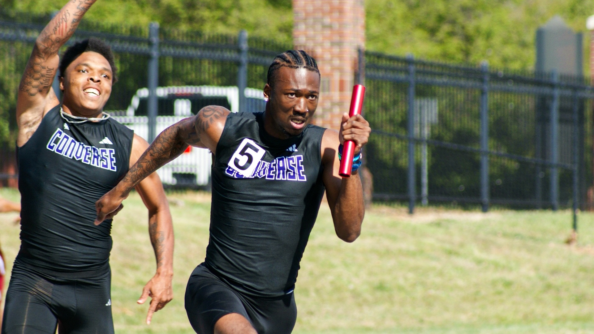 Devron Davis begins to run with the baton as Dre'Kevan Thomas cheers him on