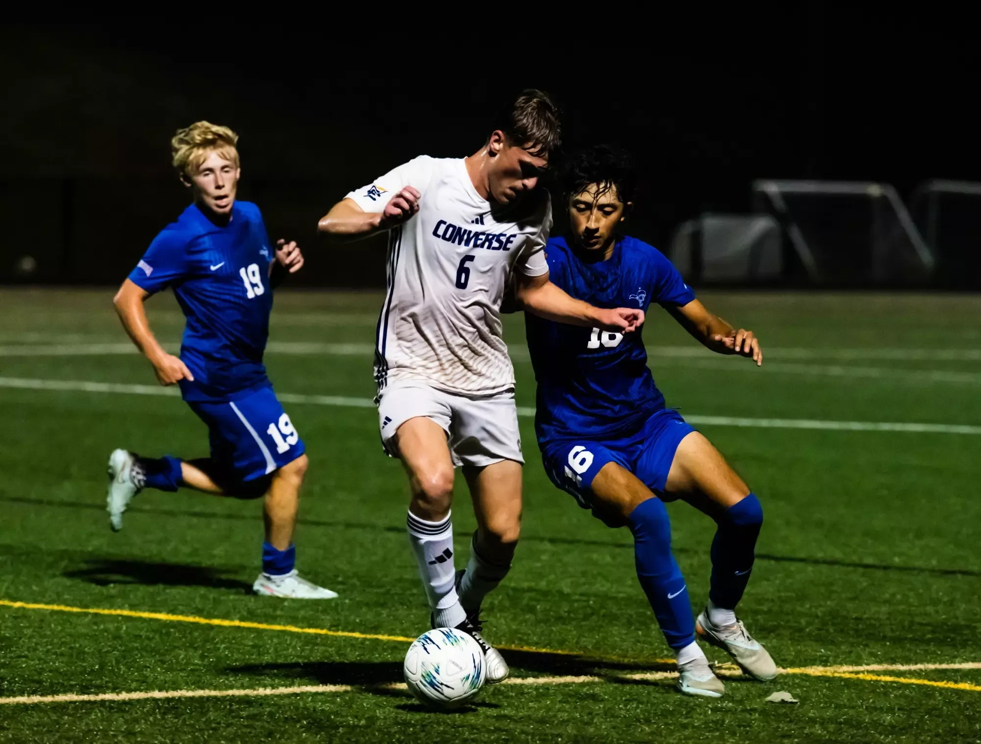Jesper Schierholz dribbles around two SMC defenders