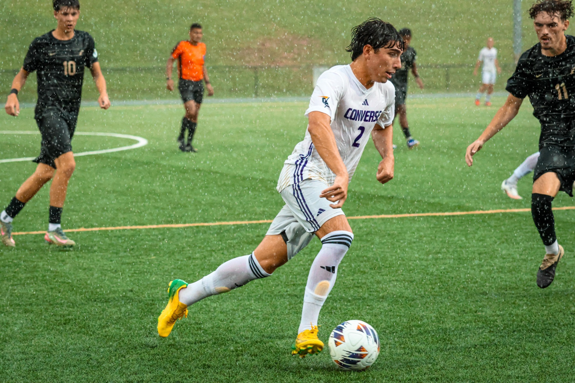 Alec Antista dribbles the ball in the rain