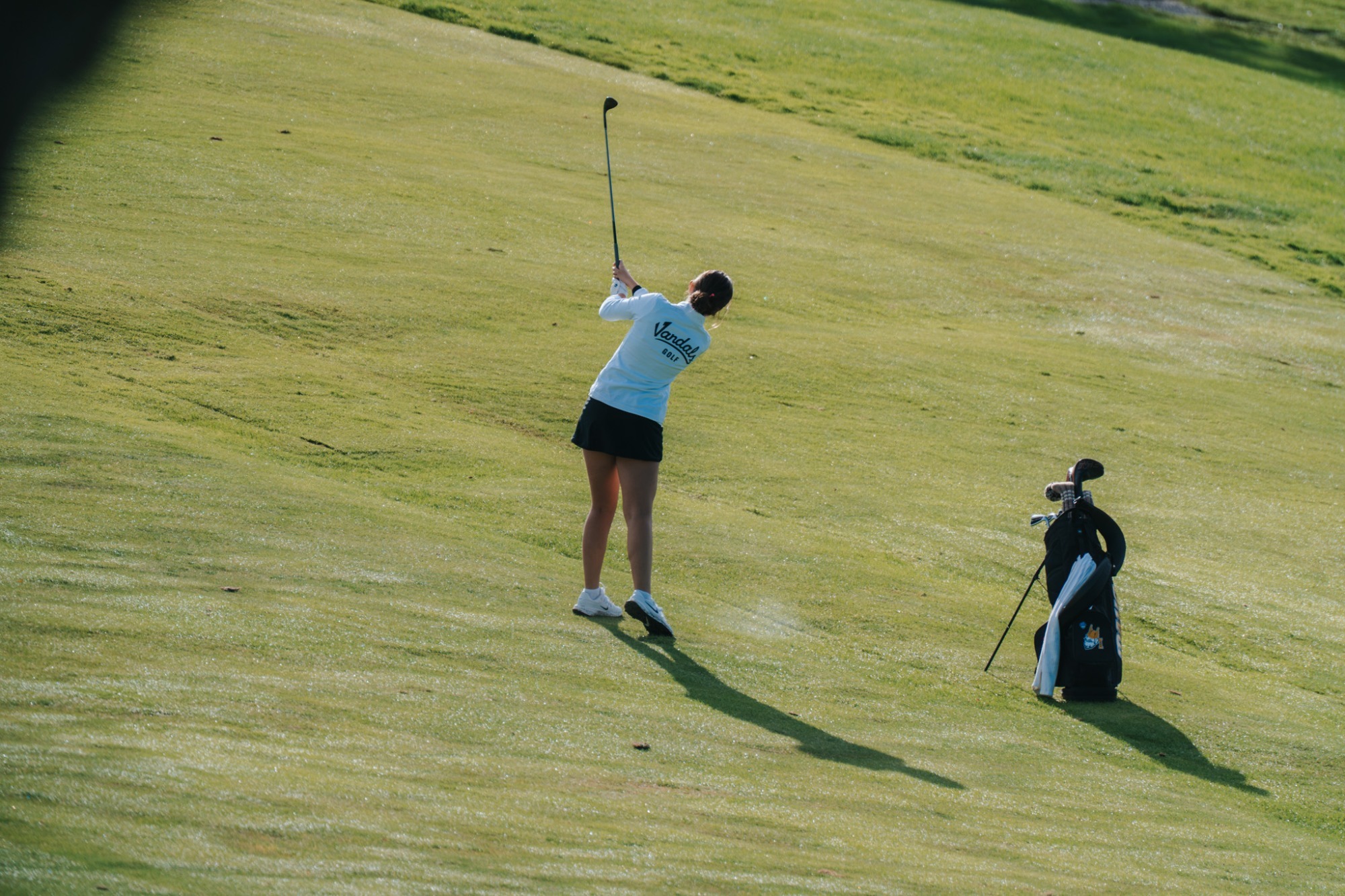 Vandal womens golf player, swinging club at practice