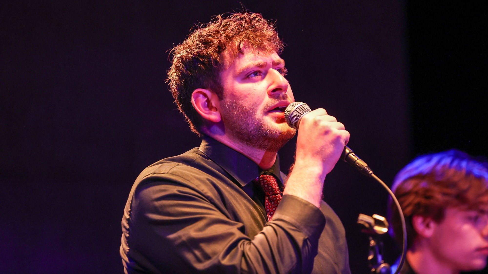 Harrison Fink '26 singing at Sharing Stages