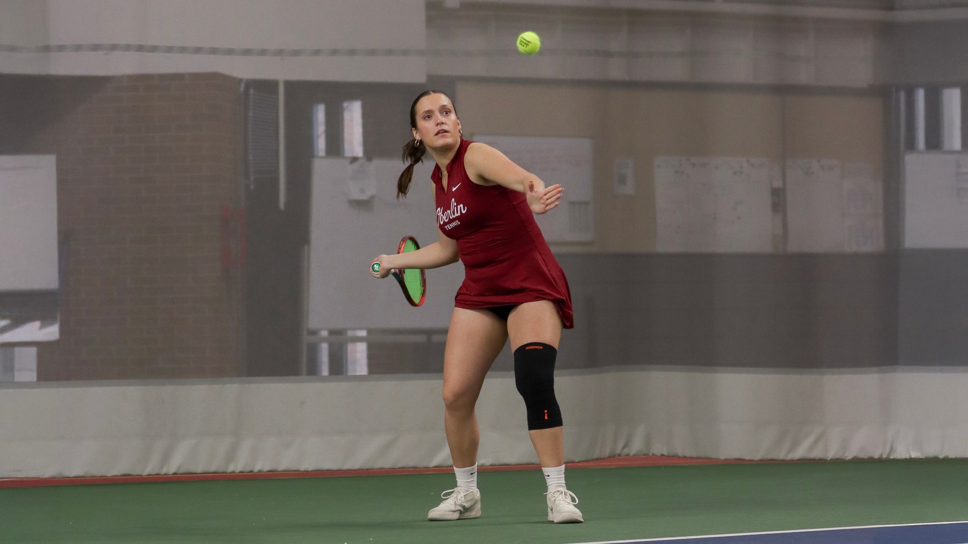 Anna Pastore winding up to hit a tennis ball