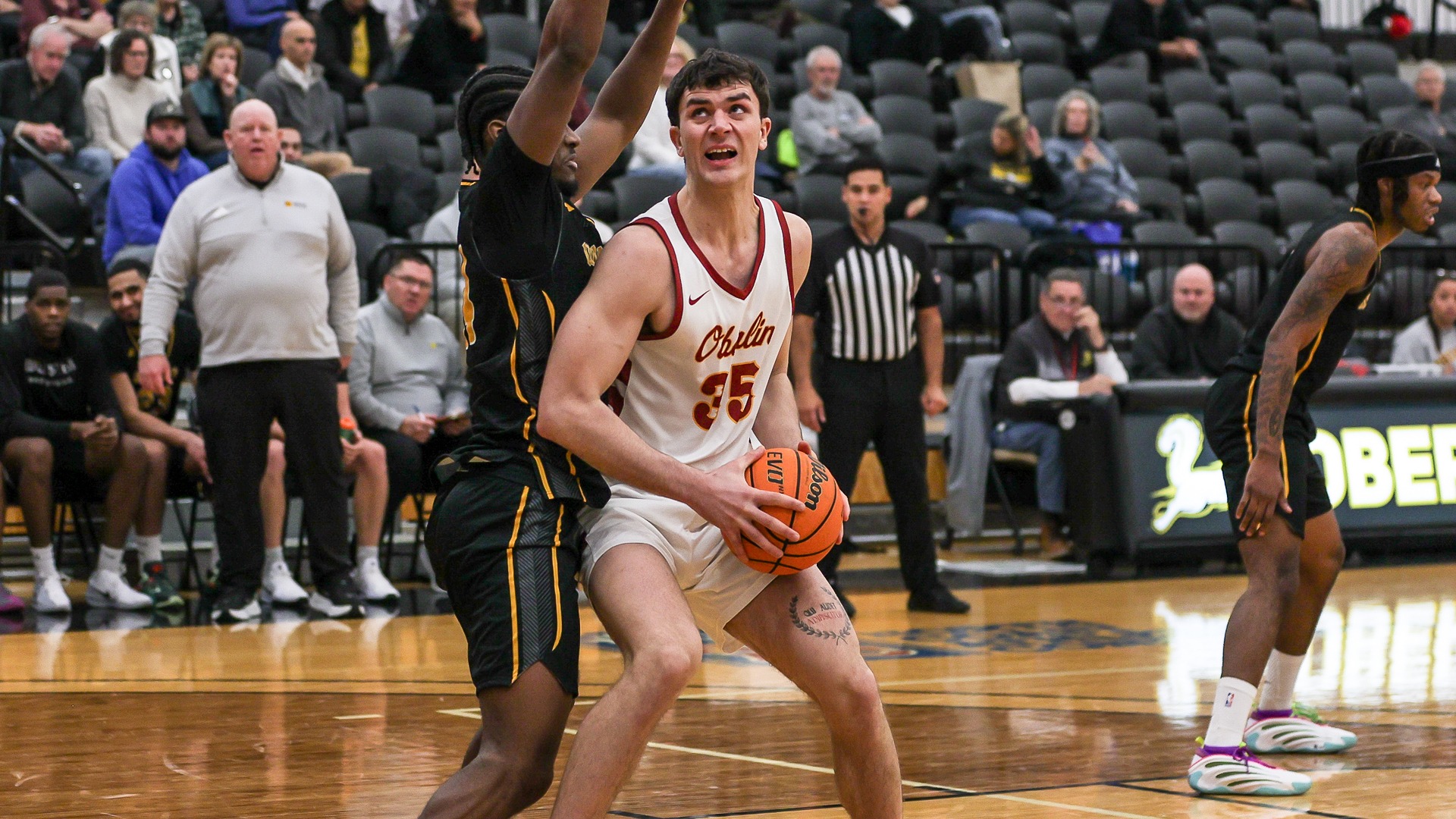 Milun Mianovic looking up to the basketball against his defender