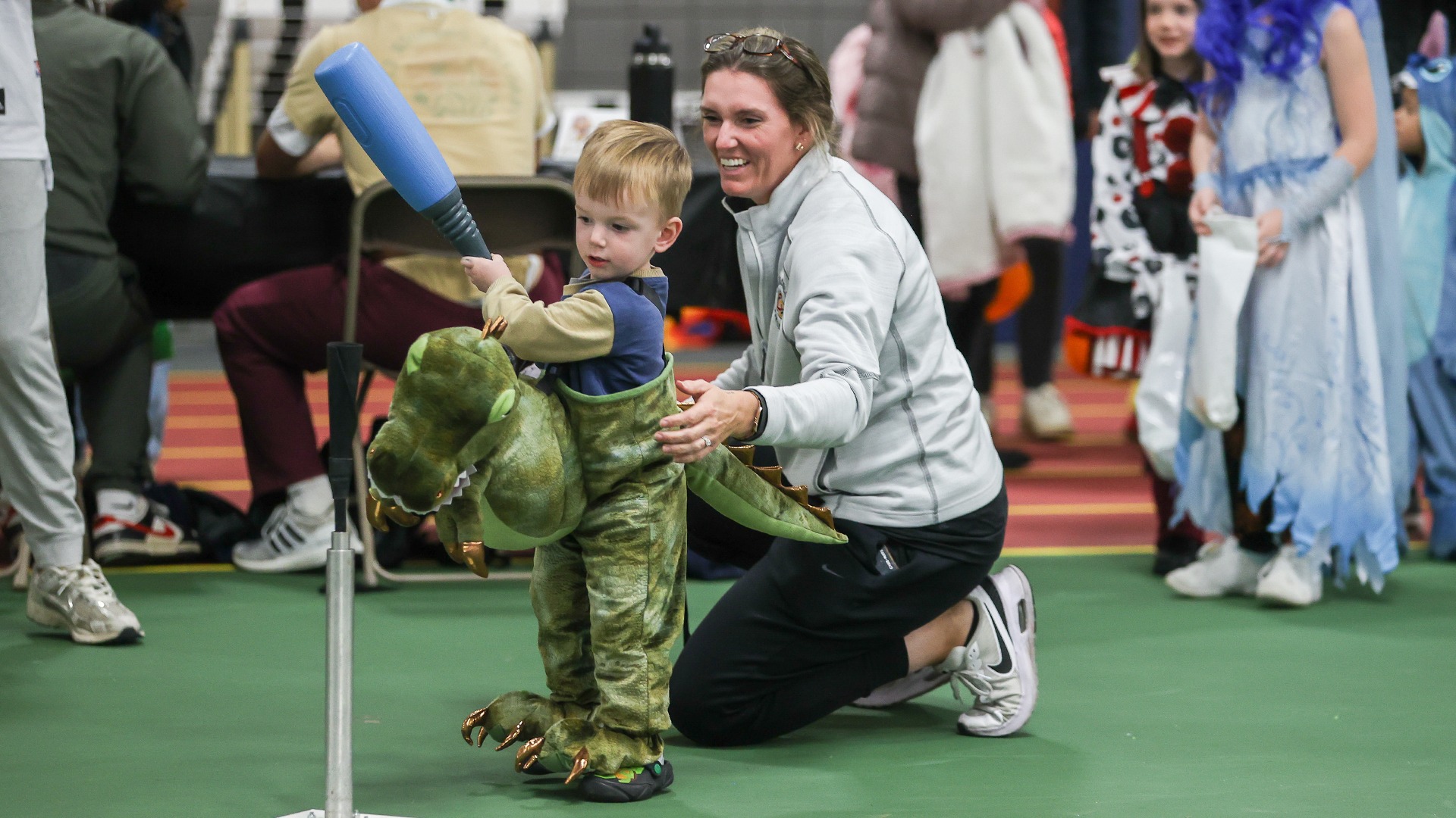 Jess West playing with kid during Track or Treat event