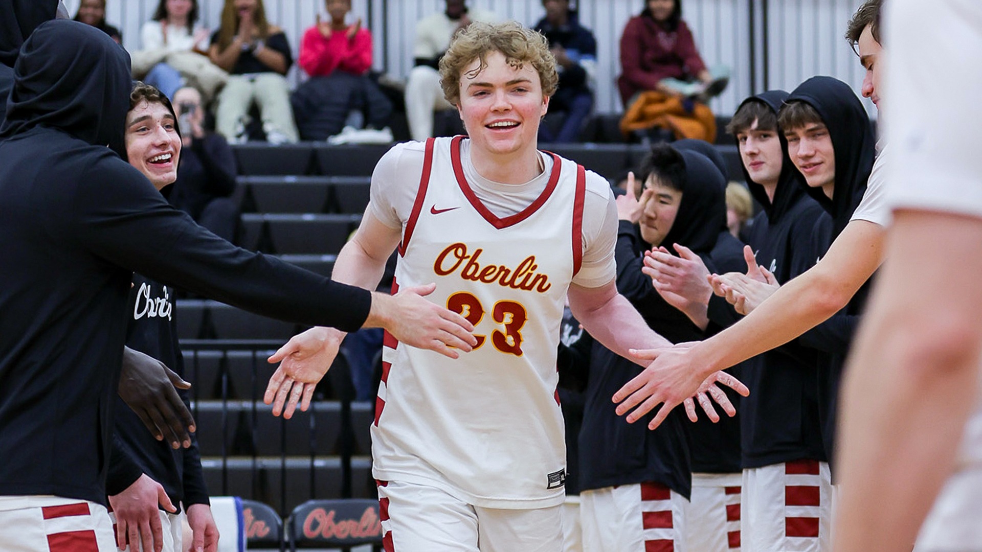 Rob Magner smiling and running past teammates