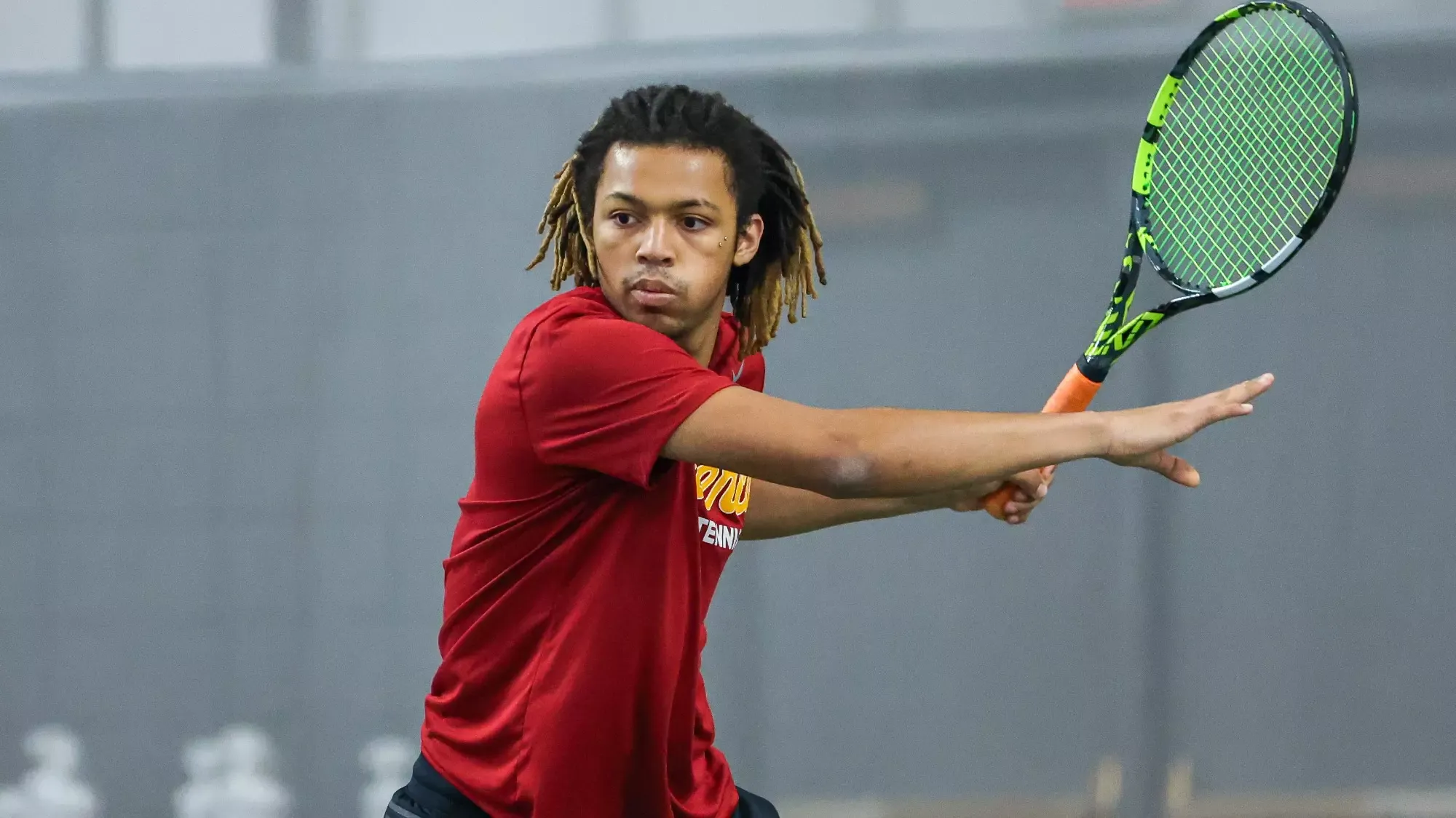 Dash Smith starting down a tennis ball, about to hit it