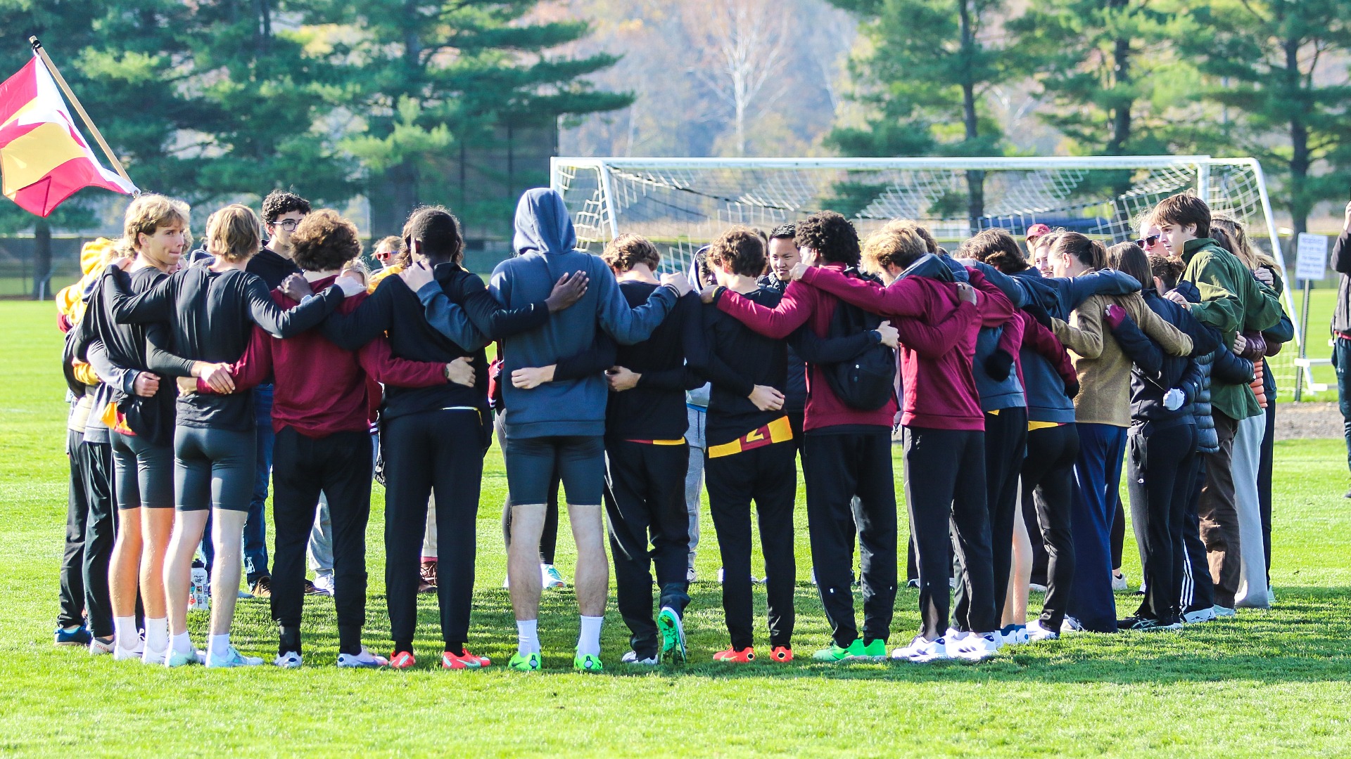 Oberlin College cross country team in a team huddle before NCAC Championships