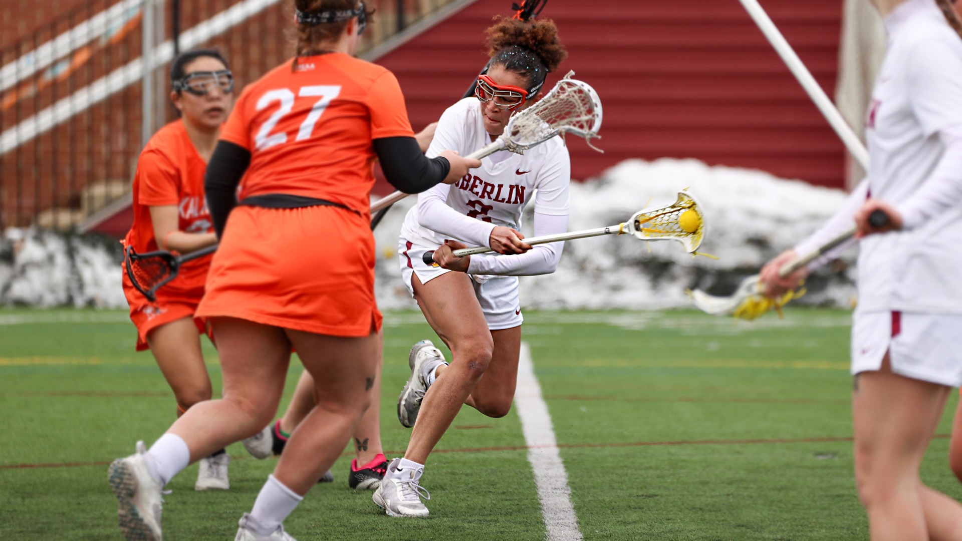 Mary Rodman shooting the the lacrosse ball low from across her body, off-hand