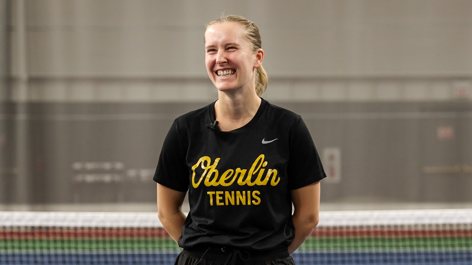 Magda Stepnik laughing during interview standing in front of net