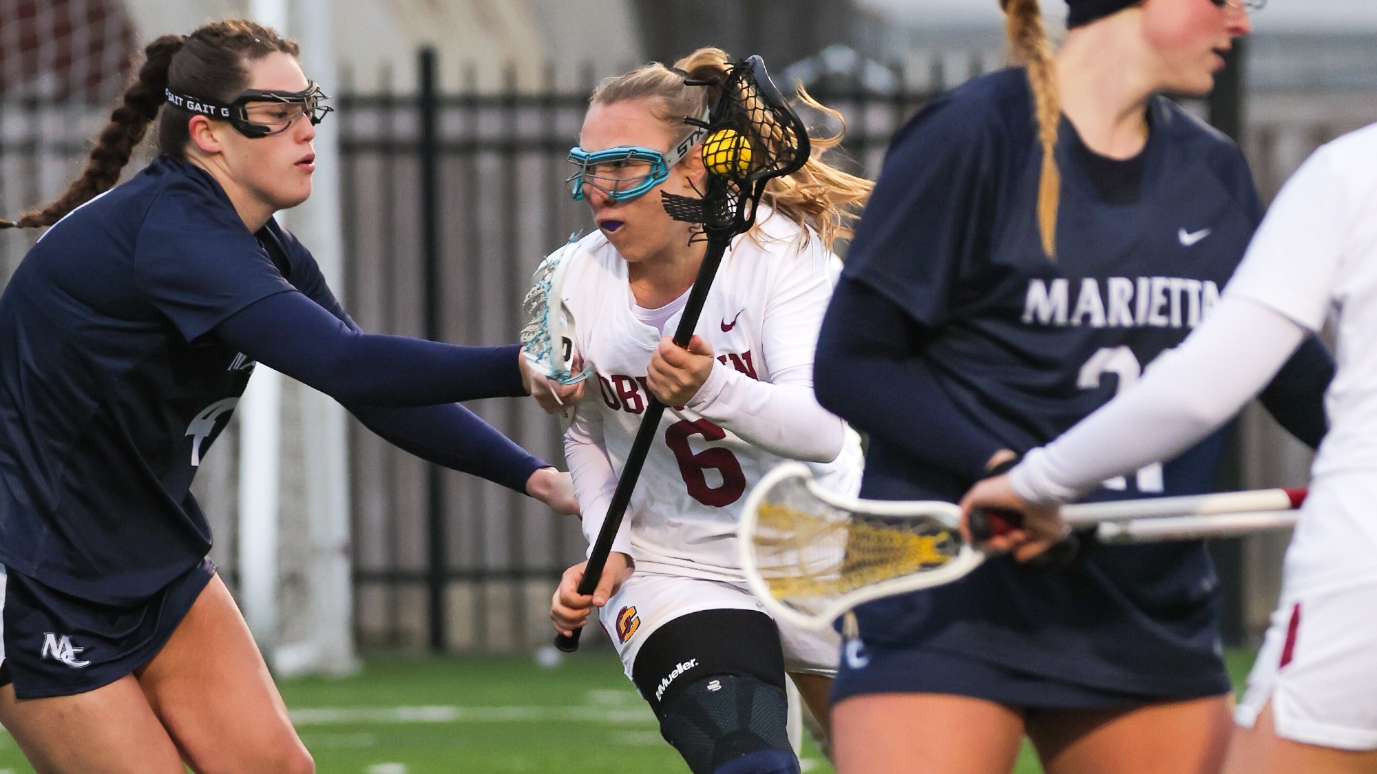 Kylie Thompson sprinting to left past defenders with lacrosse ball in her stick