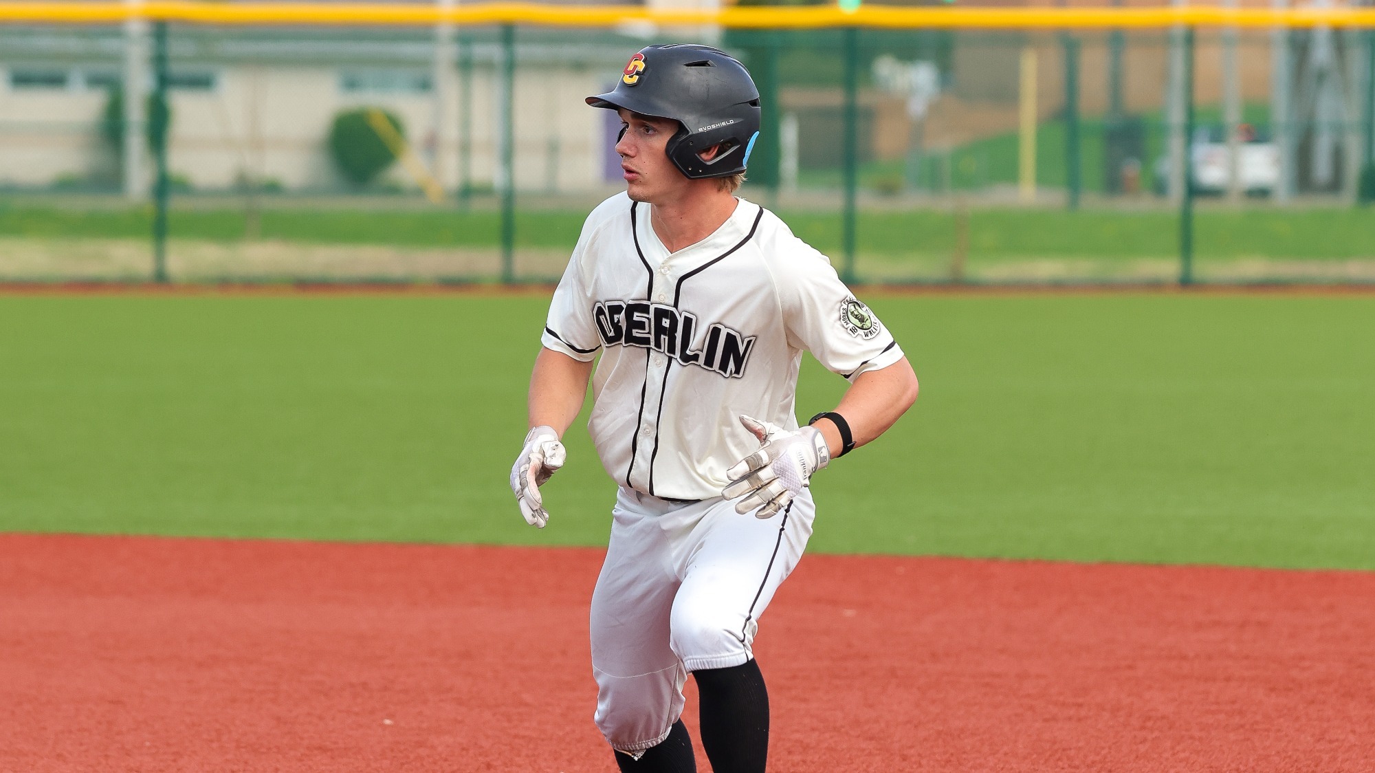 Patrick Leonard looks to the left between bases, wearing baseball helmet