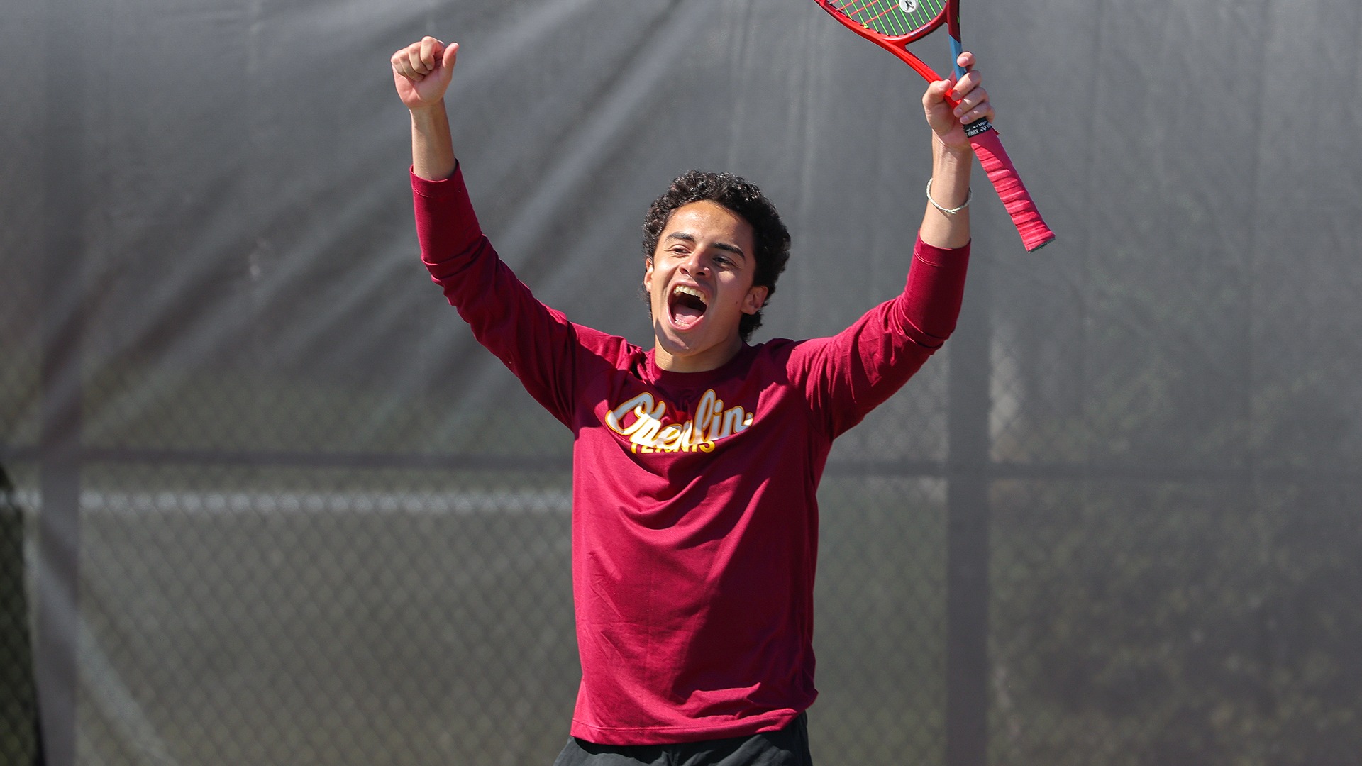 Sebastien Naginski cheering and raising his hands above his head after winning his match