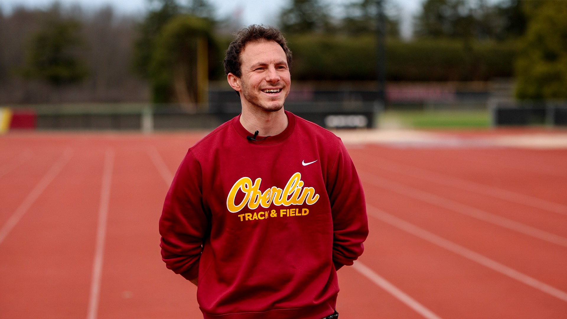 Ben Wach standing on track smiling during an interview