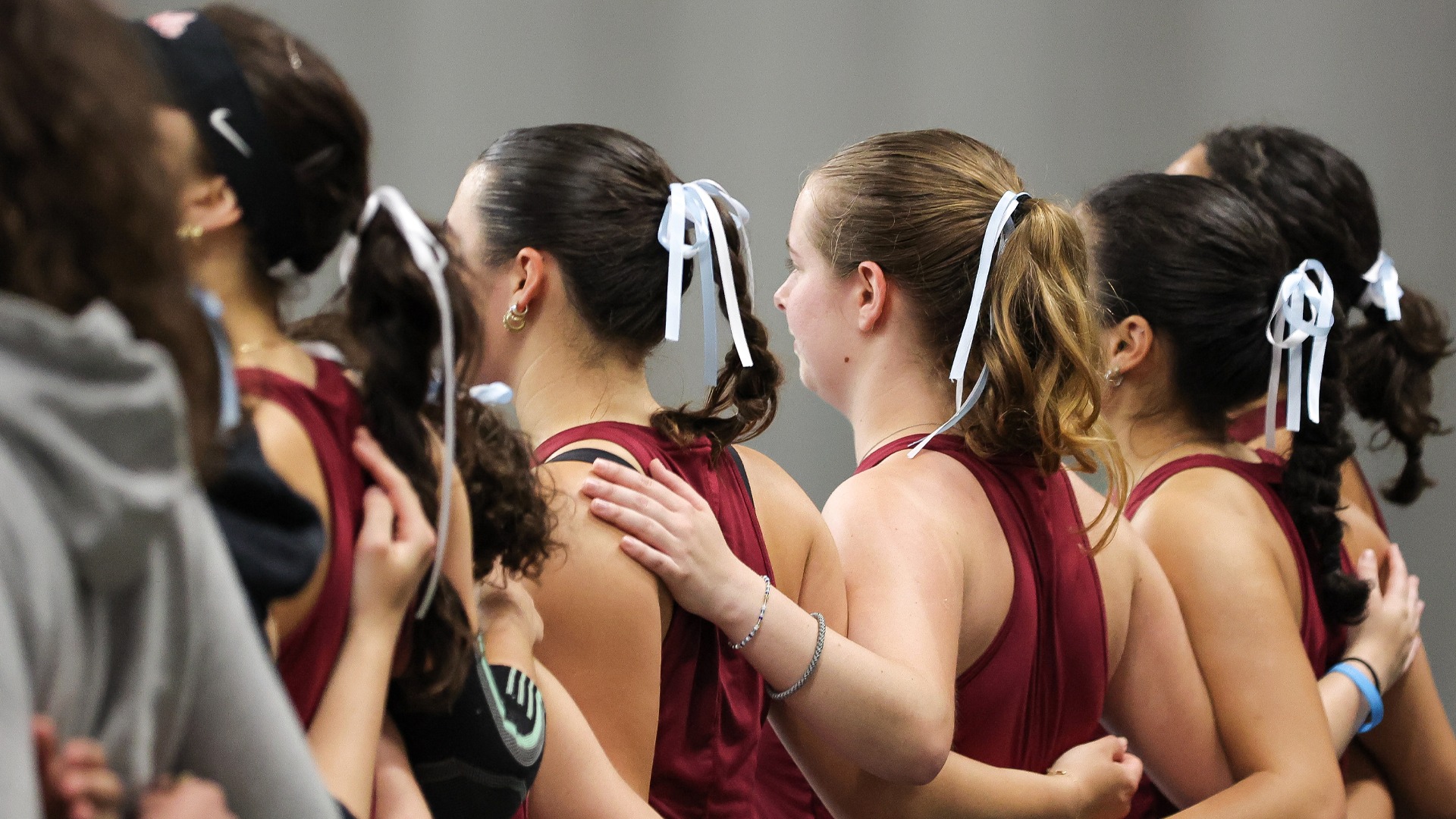Women's Tennis teammates with arms around their backs