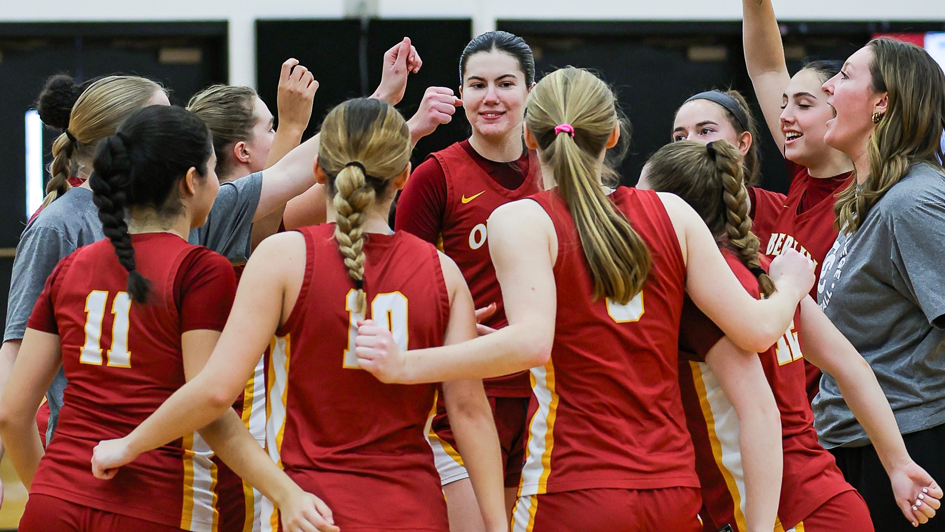 Women's basketball team celebrating in a team huddle