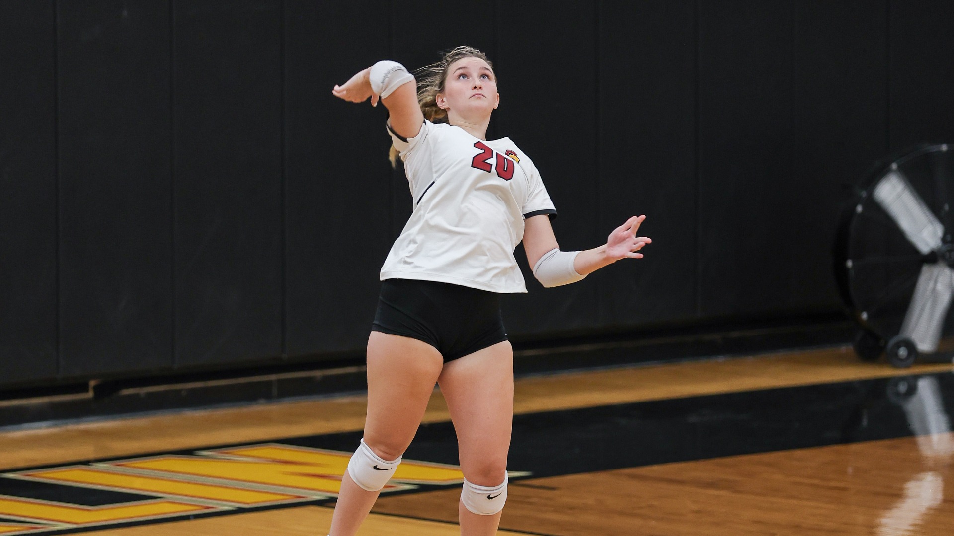 Genna Gauthier looking up at the ball as she's serving