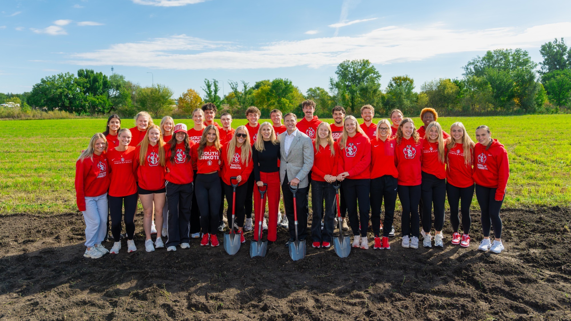 Bill and Jill Gassen pose for a photo with members of the South Dakota Track and Field and Cross Country Programs