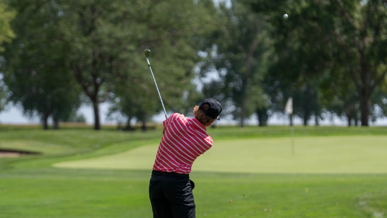 Jack Holtz chipping to the green at the Bluffs on hole No. 1