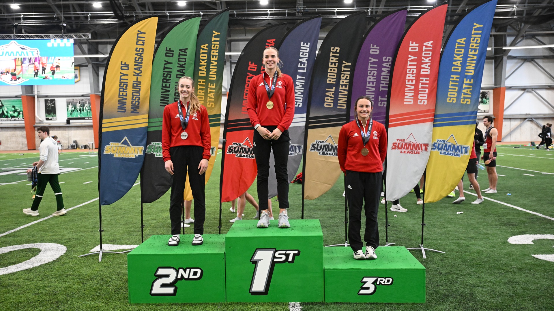 Coyotes Marleen Mülla, Anna Willis, and Eliza Aitken stand on the podium at the Summit League Championships