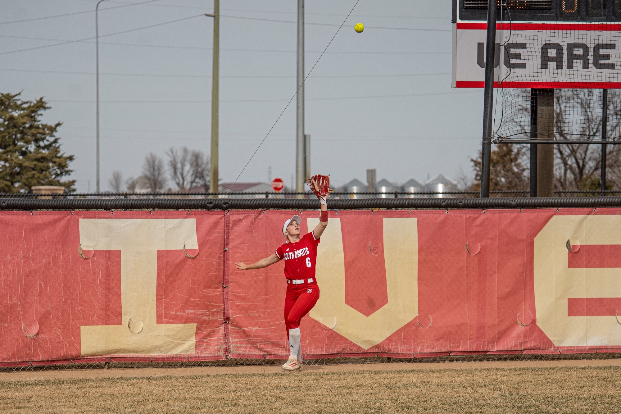 Ella McGee catching a ball against the fence