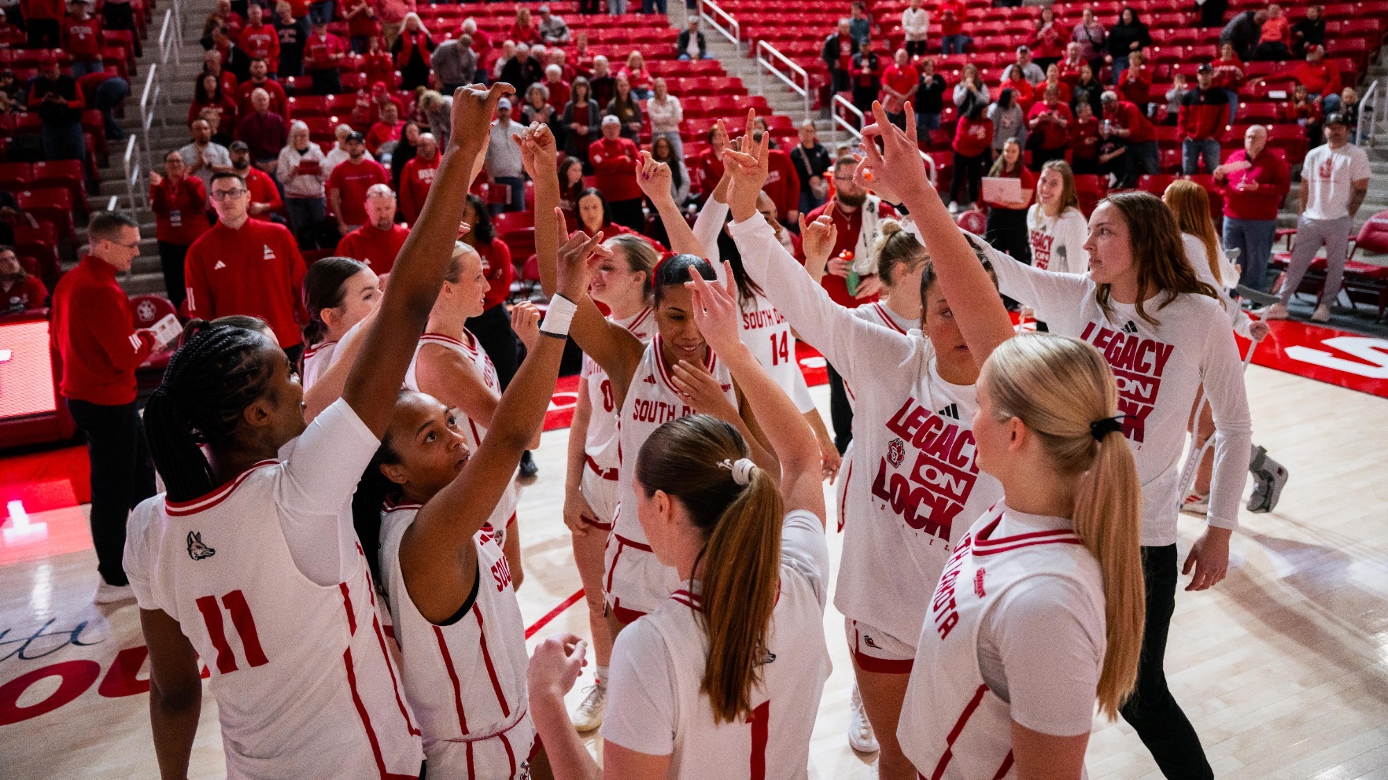 South Dakota women's basketball team huddles on the court before a game