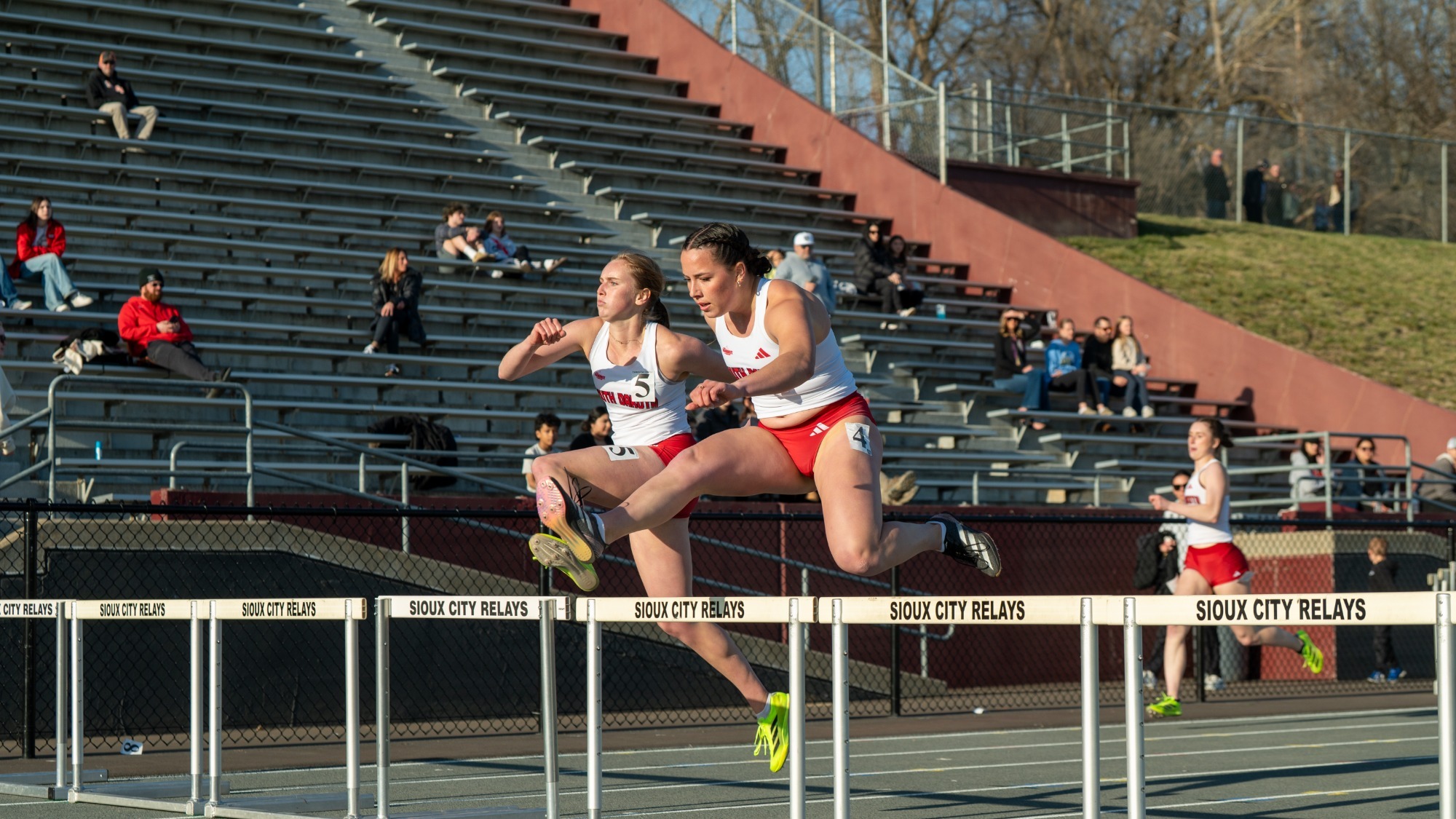 Two Coyotes compete in the 400-meter hurdles at the Sioux City Relays