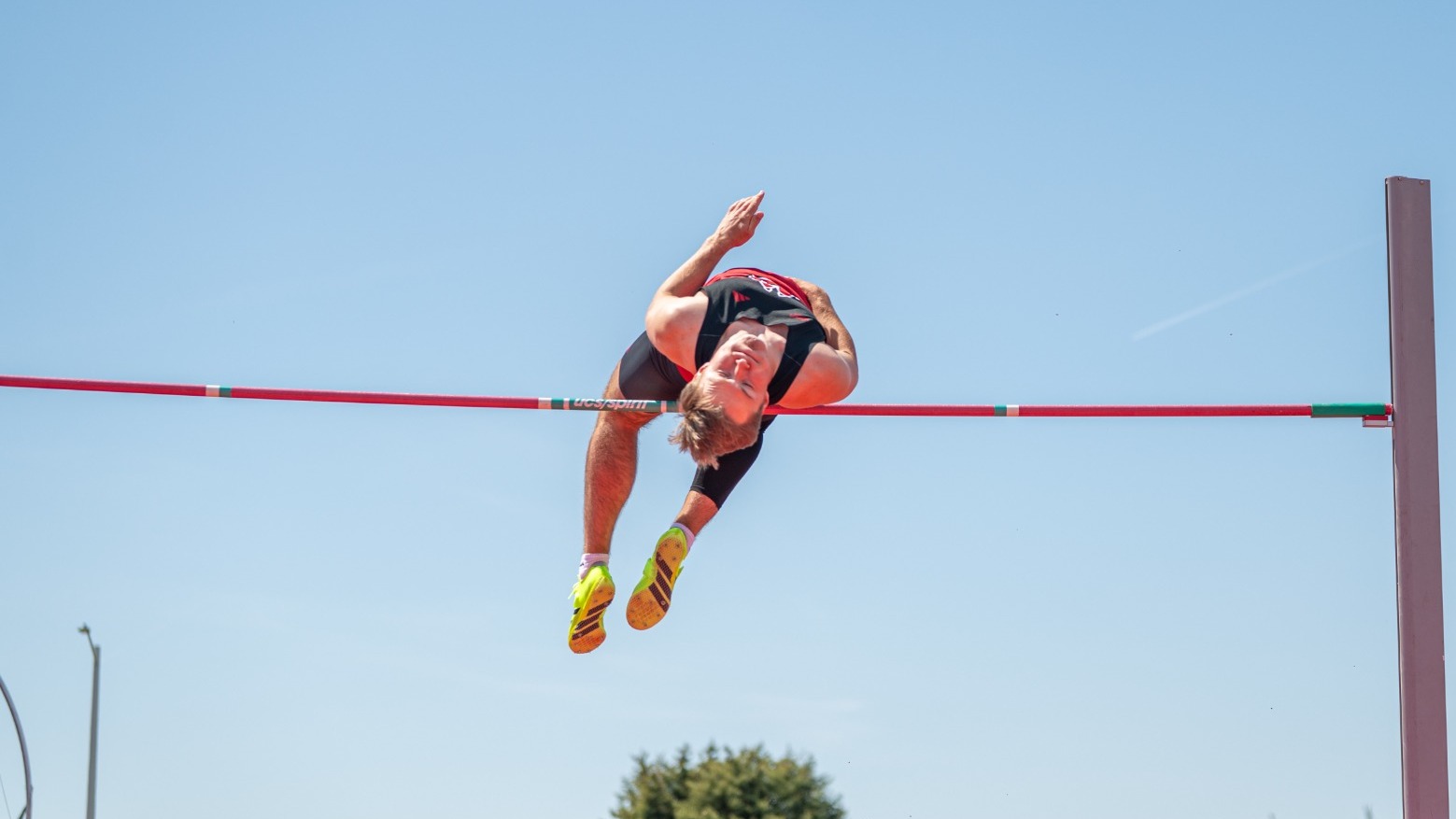 Landon Olson goes over the high jump bar at a home meet earlier this season