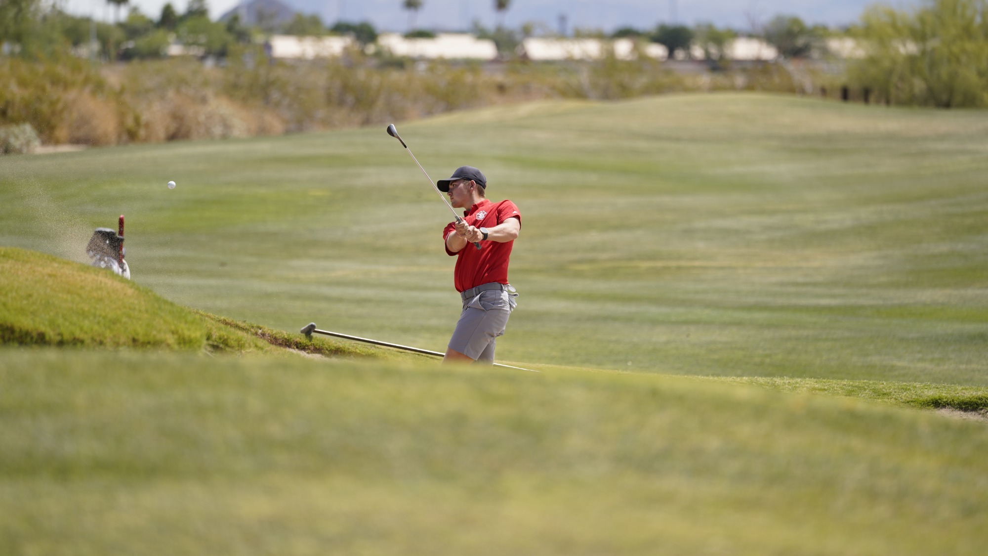 Parker Etzel pitching wedges out of a bunker at the Summit League Championship