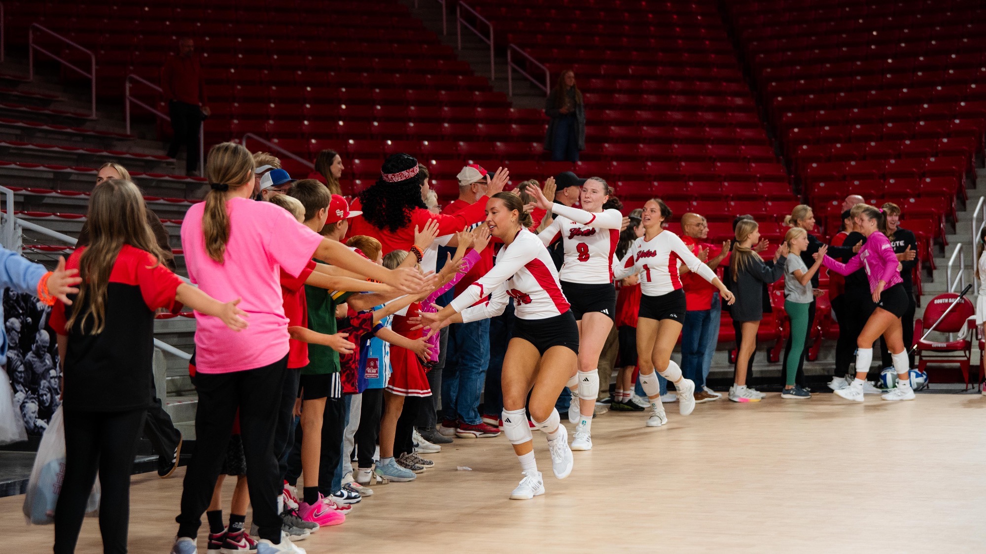 VB team high fives with fans after a win