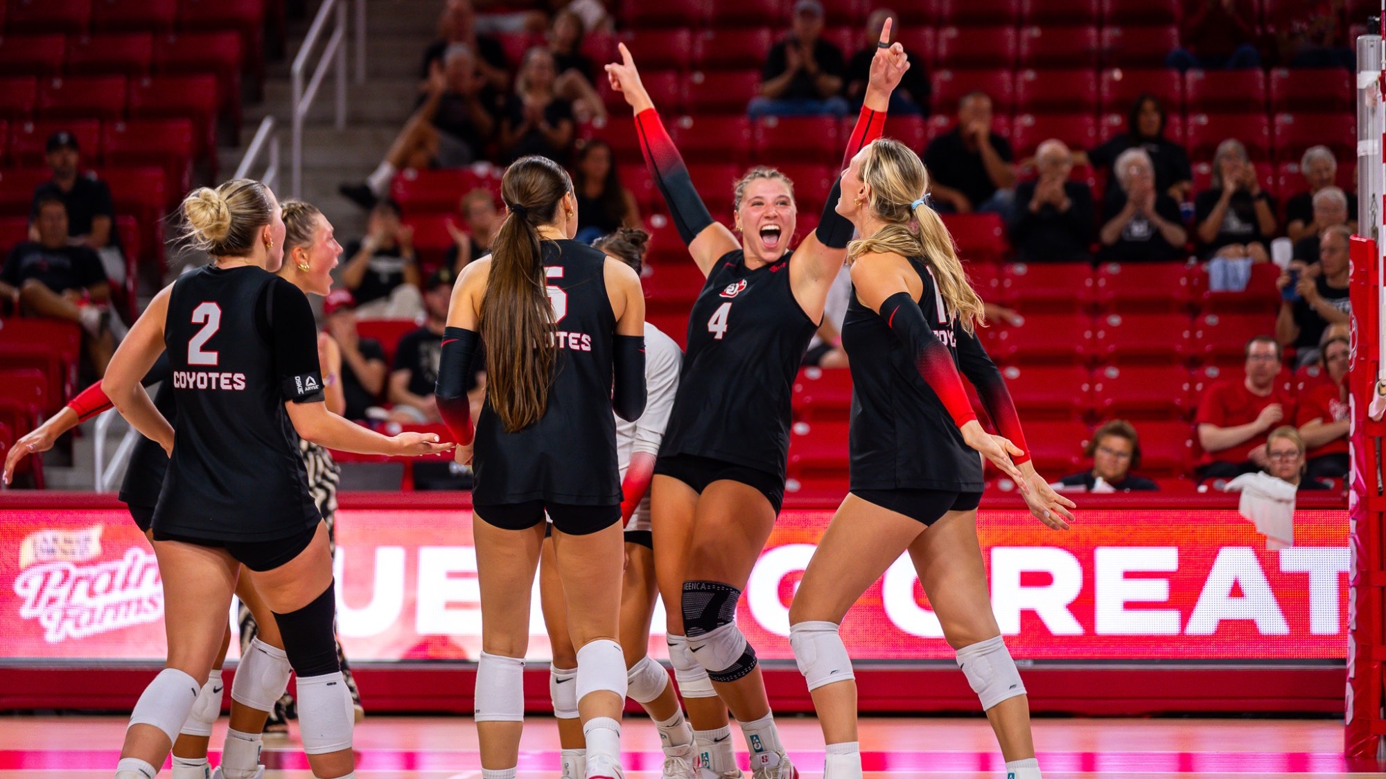 Volleyball team celebrating after a point against Utah Valley