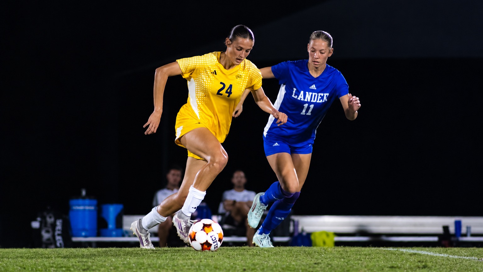 Zoie St John dribbles ball past Lander player