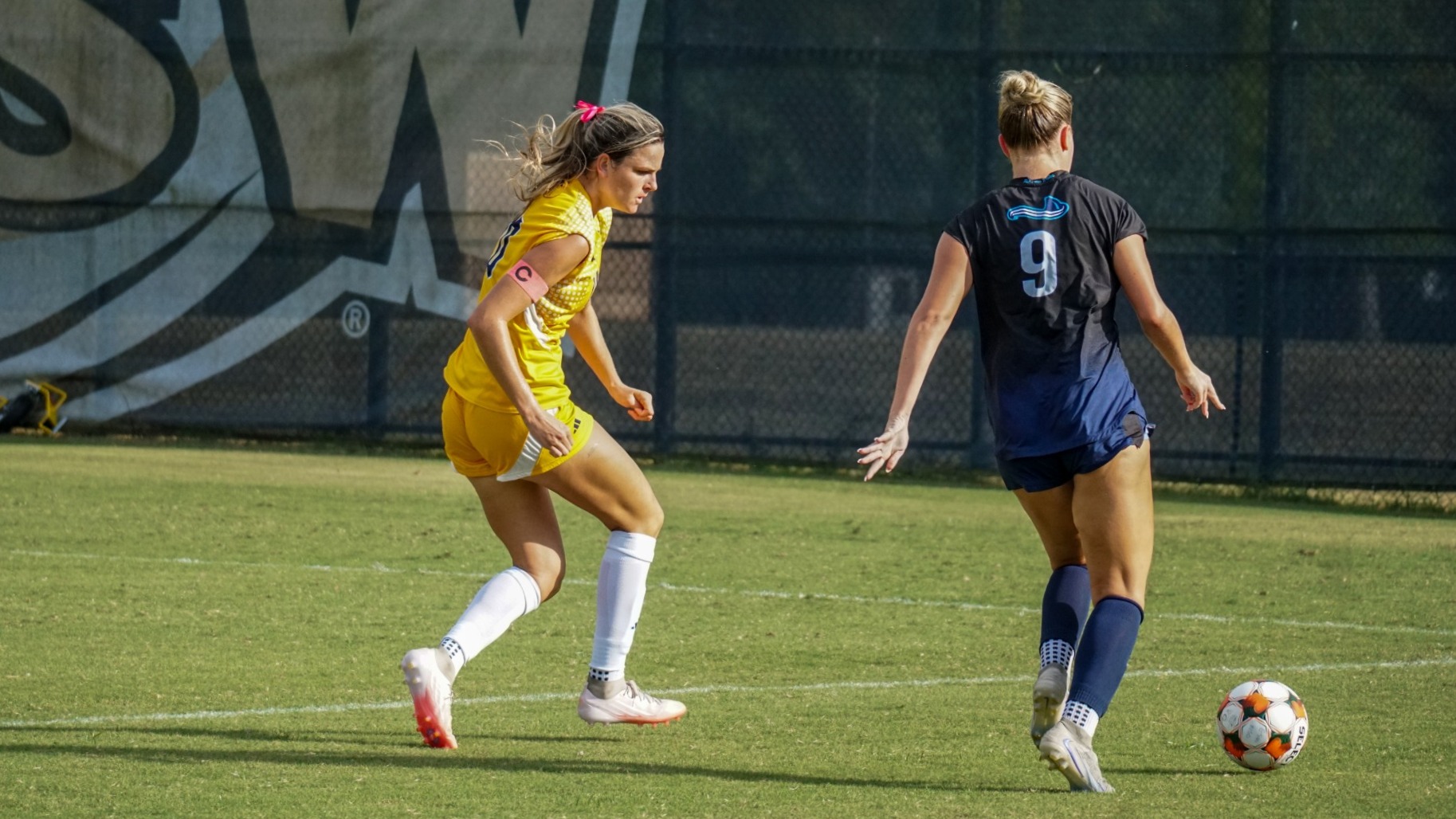 Kira Wilson on defense running alongside USC Beaufort player about to cross ball