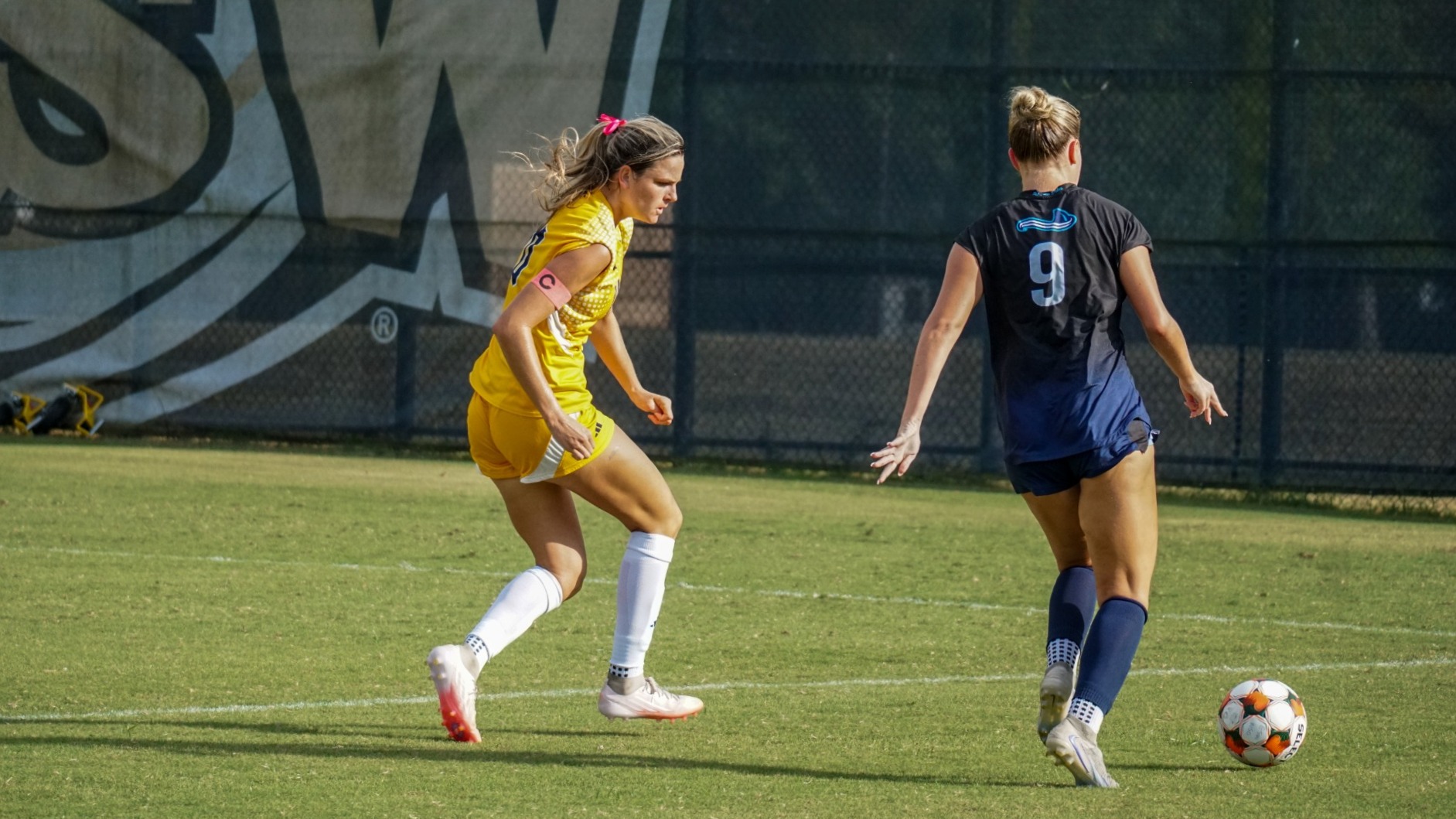 Kira Wilson on defense running alongside USC Beaufort player about to cross ball