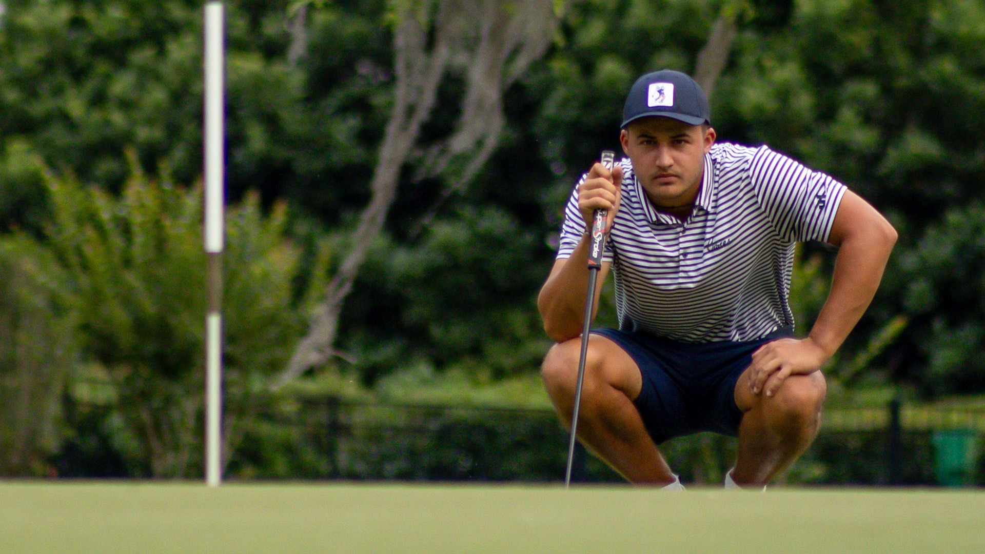 Corlouer in squat looking over putt