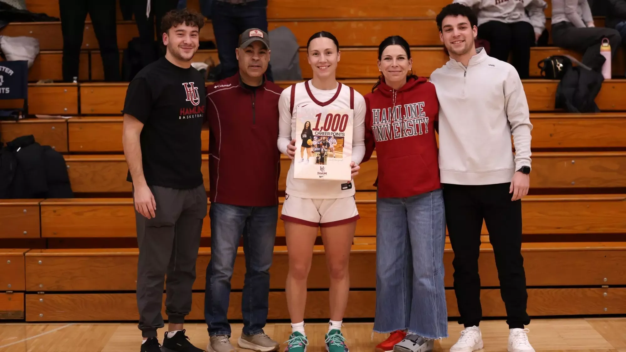 Camille Cummings and family together to celebrate her 1000th point as a Piper