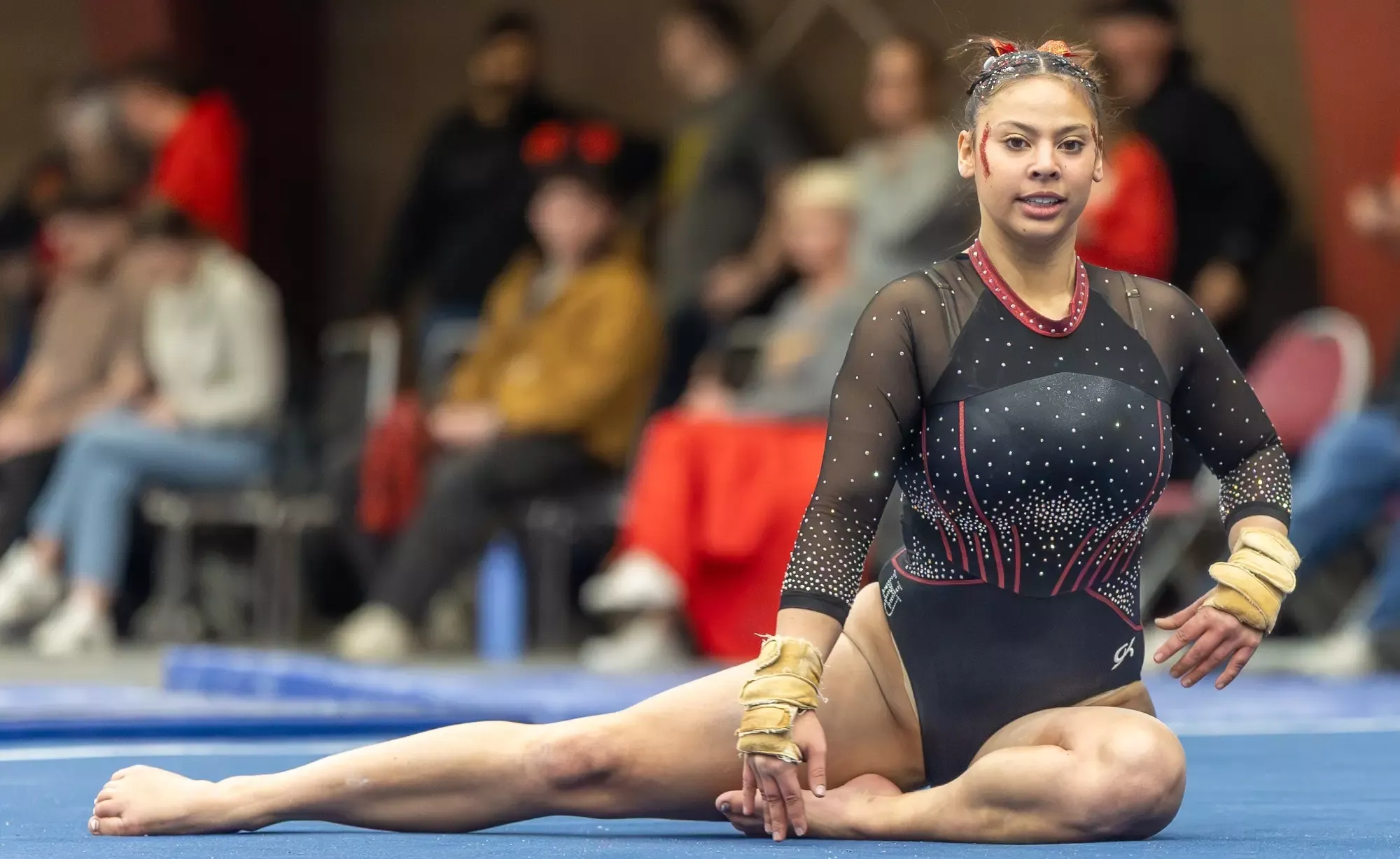 Carly Banta posing on floor, Women's Gymnastics vs Simpson
