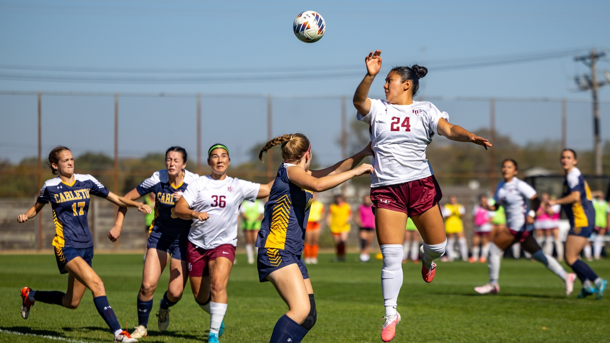 Elysse Tanaka jumping up for a header against Carleton