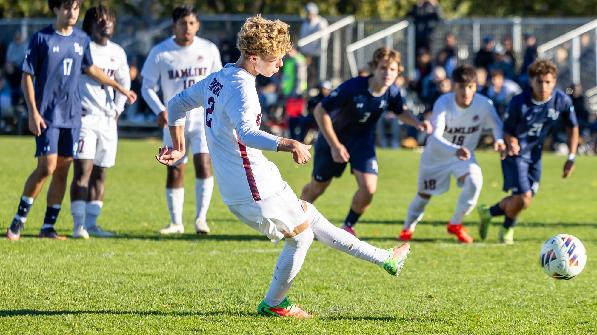 Finley R. kicking the ball against Carleton