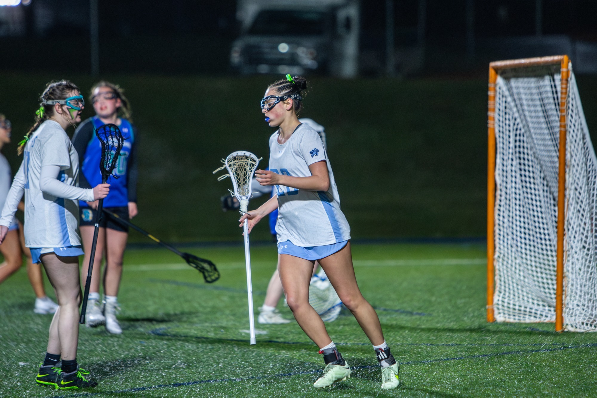 Women's lacrosse player scoring goal