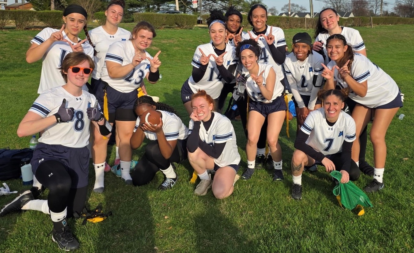 Harford women's flag football team poses for a group photo at Manor College after winning its first game in program history.
