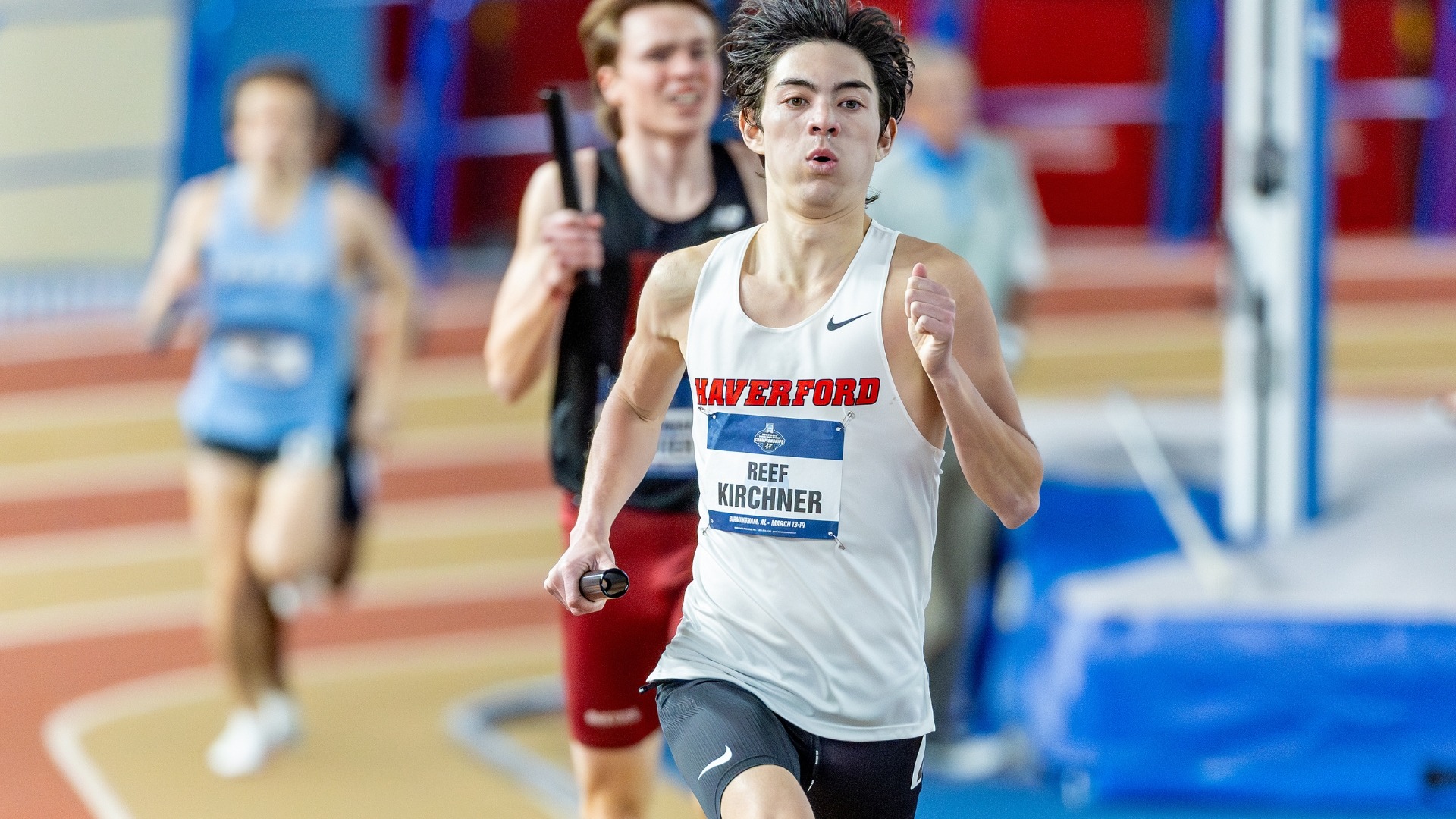 Haverford College's Reef Kirchner sprints during a relay race at an indoor track meet. He wears a white 