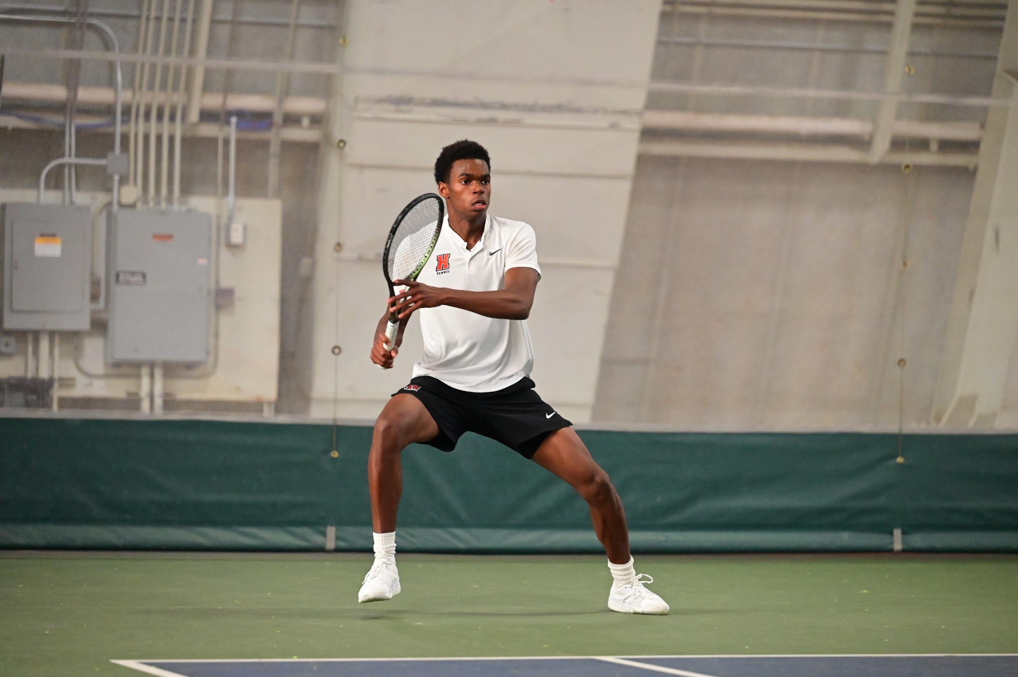 Lucio Kombo serves in a Haverford polo shirt