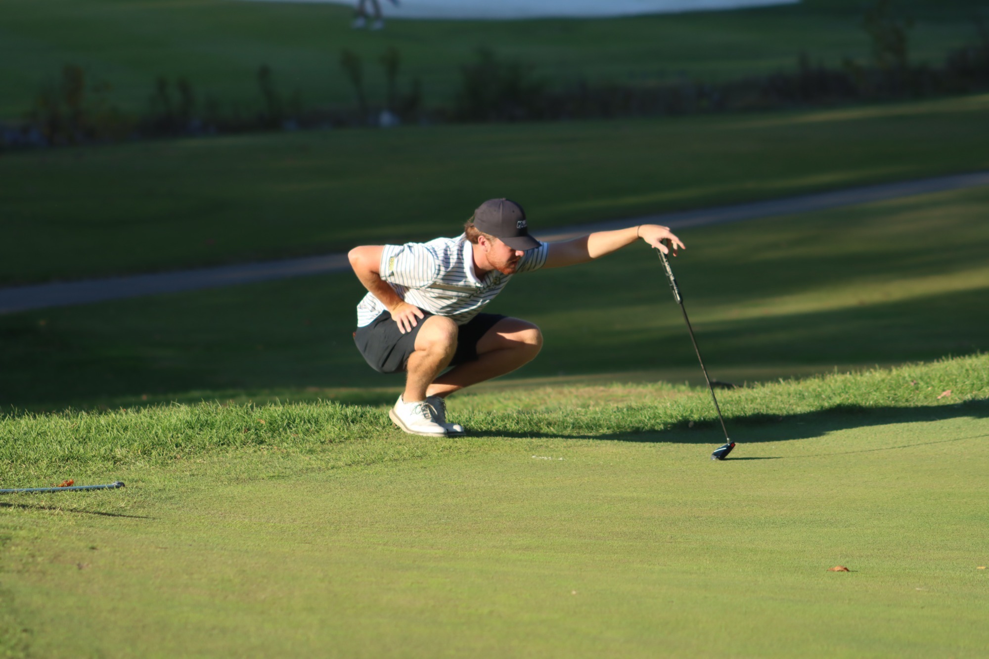 Men's Golfer evaluating a putt