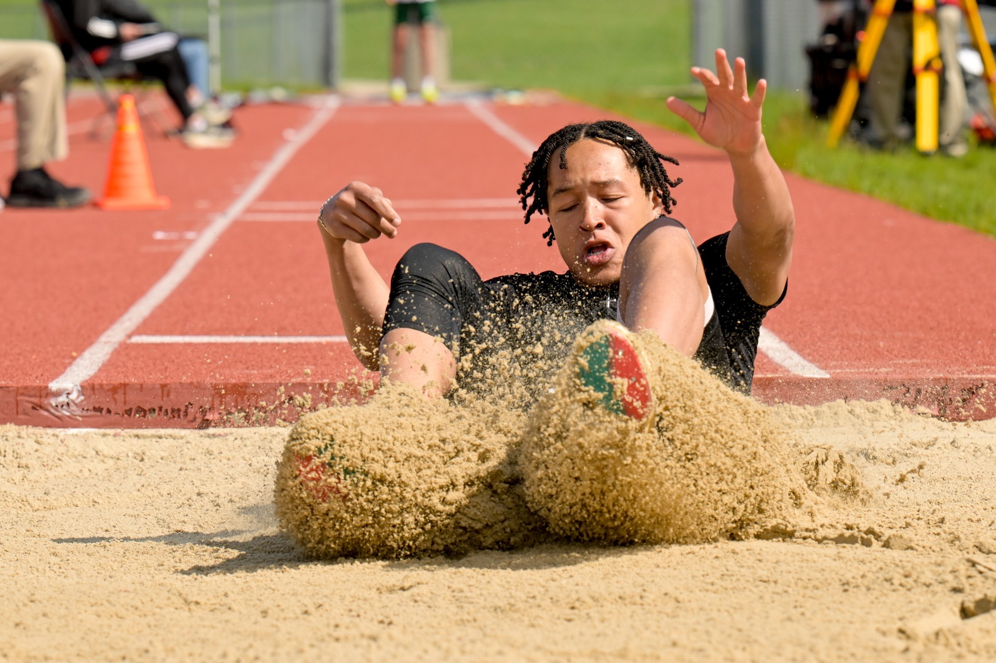 Jerron Baker lands in the sand pit in the triple jump