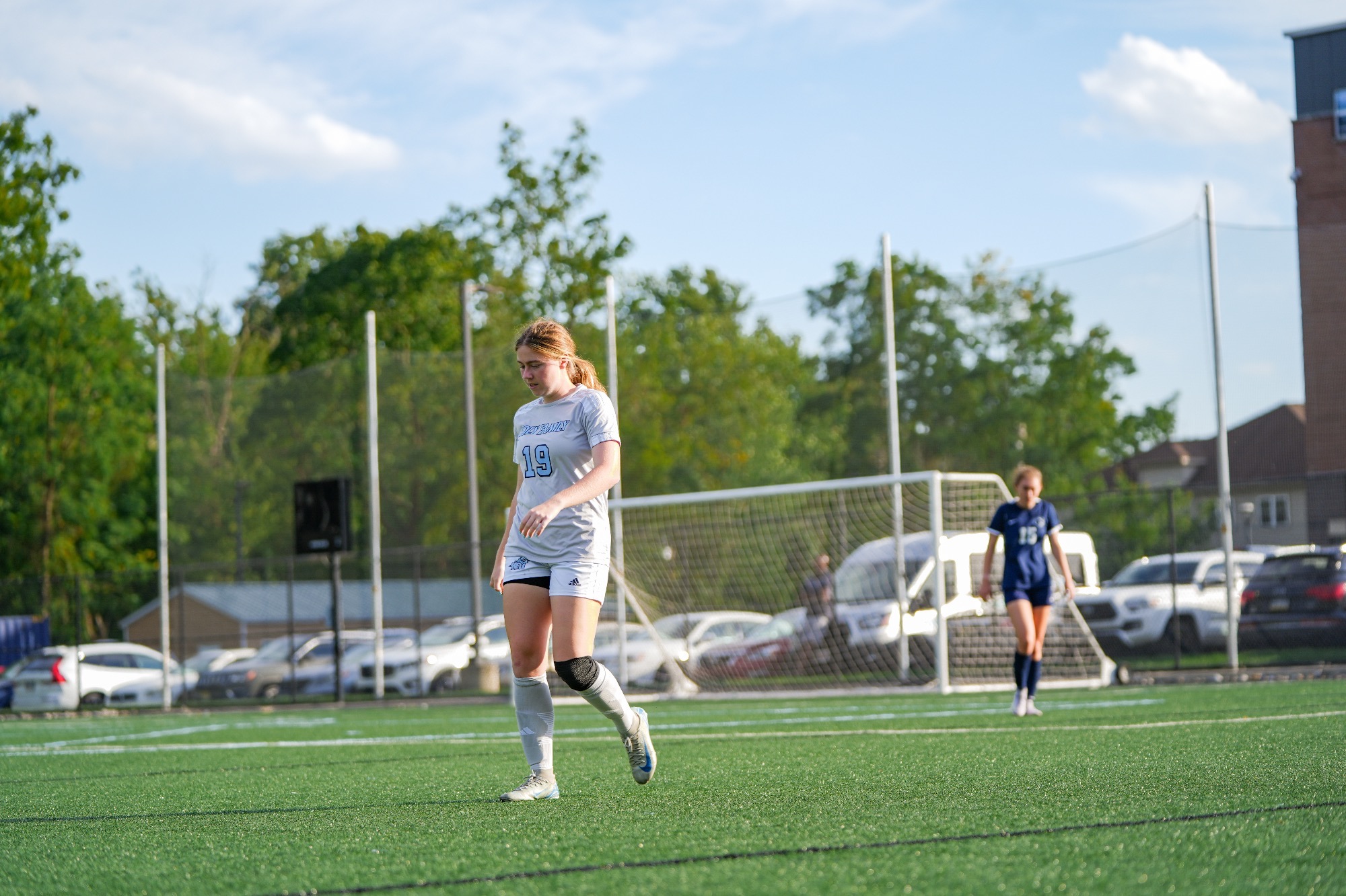 Katelyn Perazzola walking on the field, head slightly down 