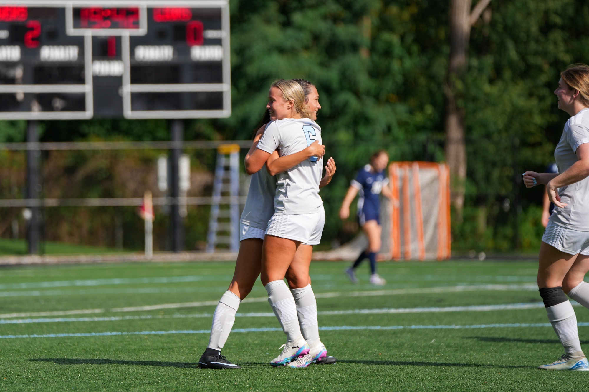 Kenna Rozanski and Kayla Balisalisa hug on the field